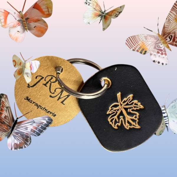 Porte clefs feuille d'érable couleur noire fond papillon